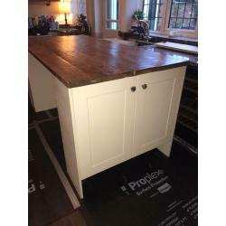 Cream shaker style kitchen island with cupboards and solid wood top